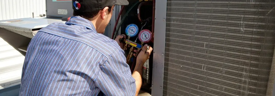 HVAC technician servicing a condenser unit in West Caldwell