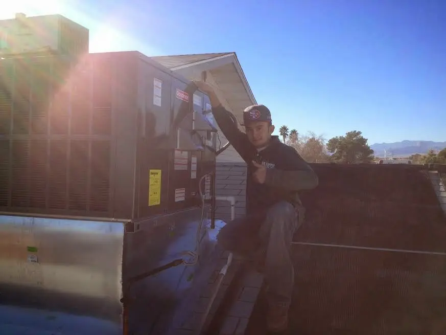 HVAC technician performing AC Tune-Up on a rooftop unit in West Caldwell